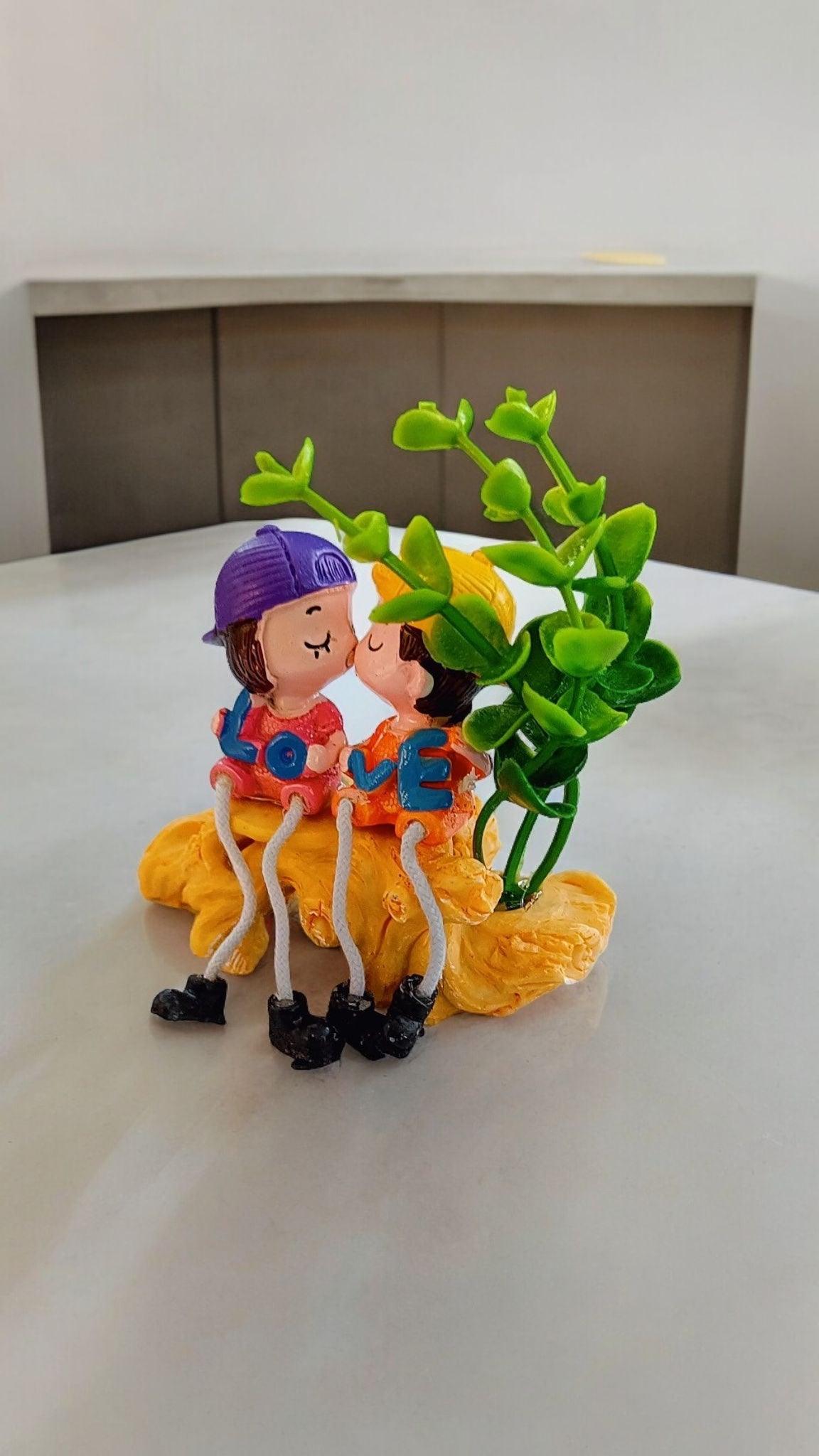 Cute Kissing Couple with Hanging Legs Sitting on the Wall