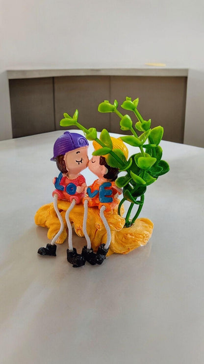 Cute Kissing Couple with Hanging Legs Sitting on the Wall
