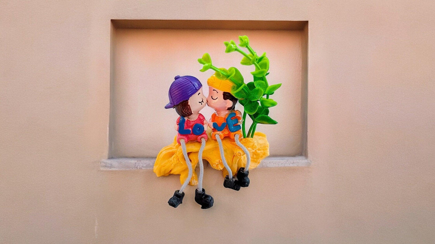 Cute Kissing Couple with Hanging Legs Sitting on the Wall