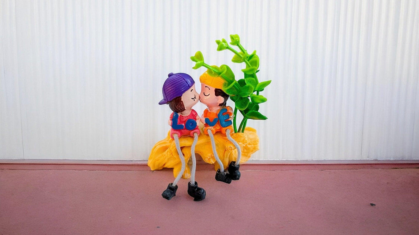 Cute Kissing Couple with Hanging Legs Sitting on the Wall